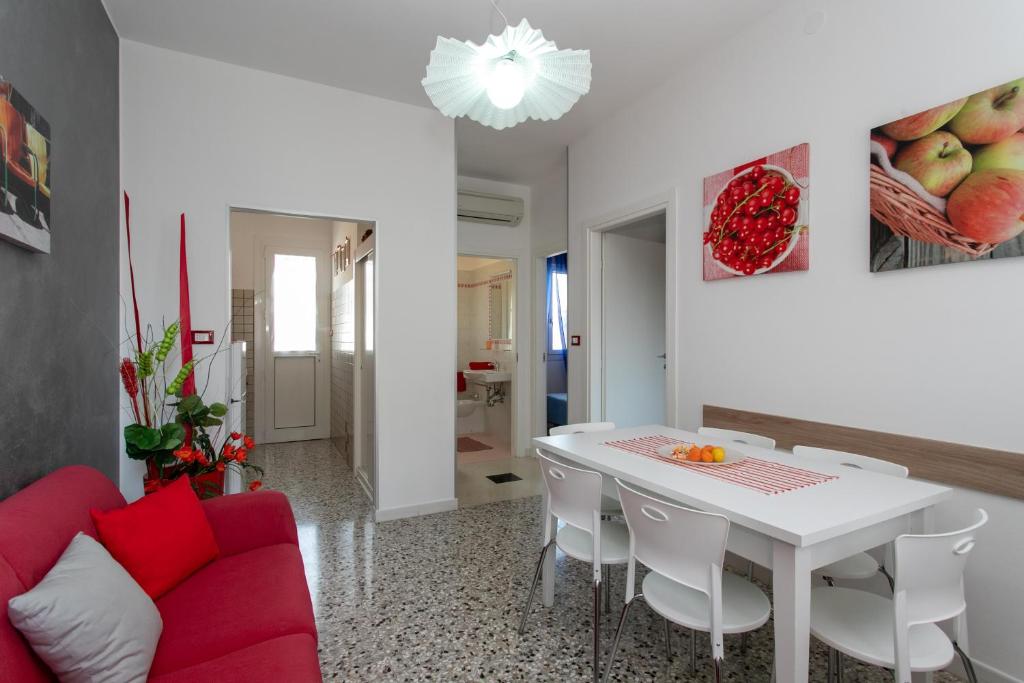 利多迪耶索罗Appartamenti Bedin, JESOLO LIDO的客厅配有白色桌子和红色沙发