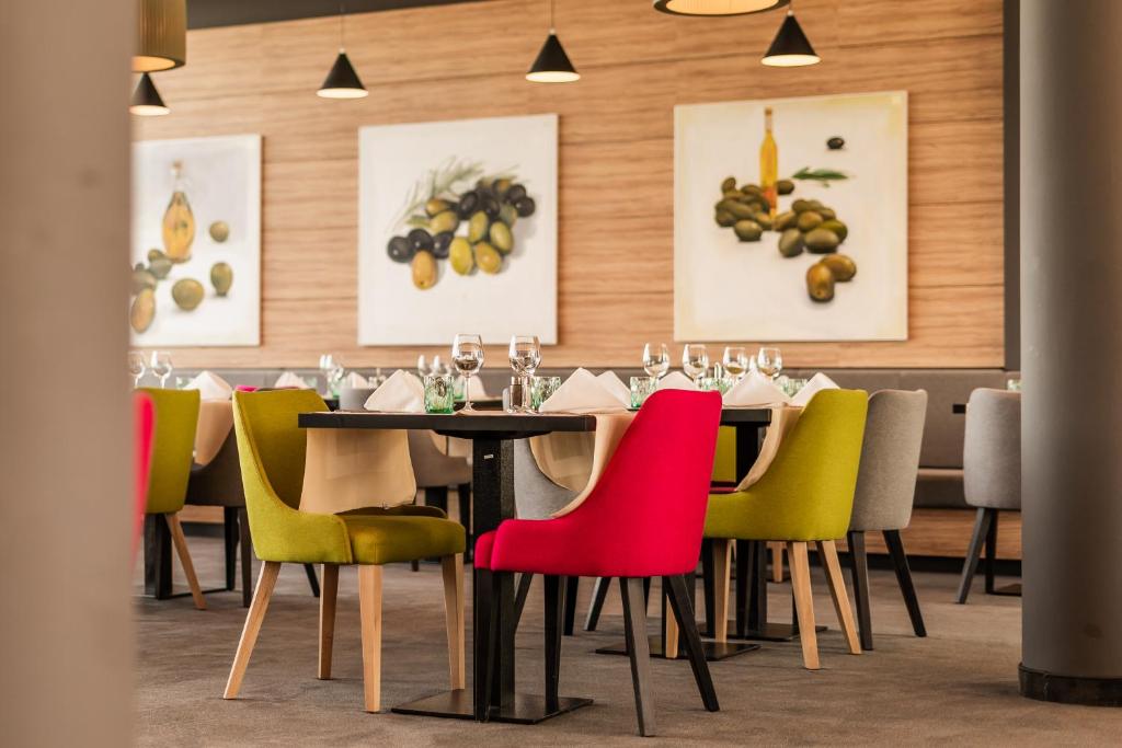 诺瓦利娅Hotel Olea的一间配备有桌子和五颜六色椅子的用餐室