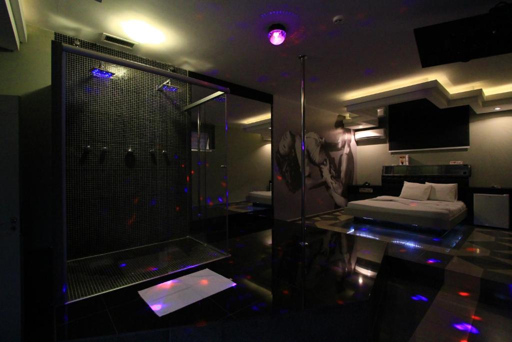 里贝朗普雷托Movie Inn Motel e Hospedagem的带淋浴的浴室和客房内的一张床