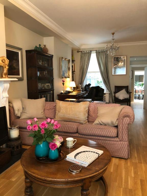 伦敦Victoria Villas的客厅配有沙发和鲜花桌