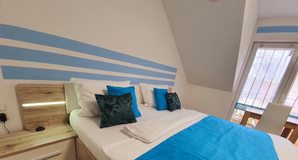 鲁斯特Kempf Apartments的一间卧室配有一张带蓝色和白色枕头的床