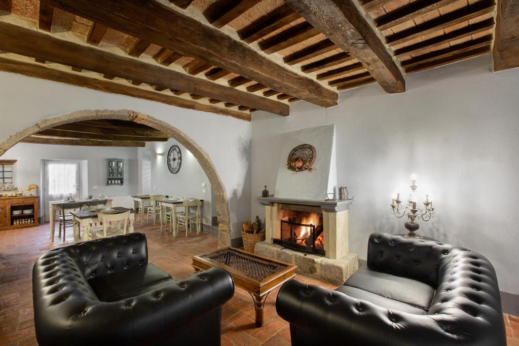 阿巴迪亚圣萨尔瓦托雷B&B Gli Archi的客厅配有2把皮椅和壁炉