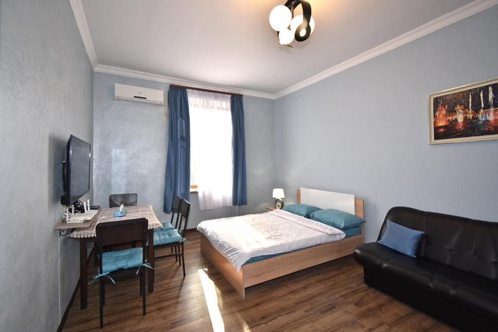 埃里温Apartment near Sasundci Davit Metro Station的一间卧室配有一张床、一张桌子和一张书桌