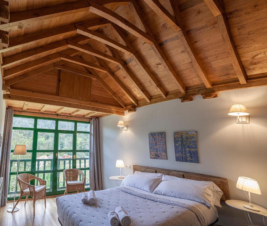 萨拉斯La Figal de Xugabolos, Salas的一间卧室设有一张大床和一个大窗户