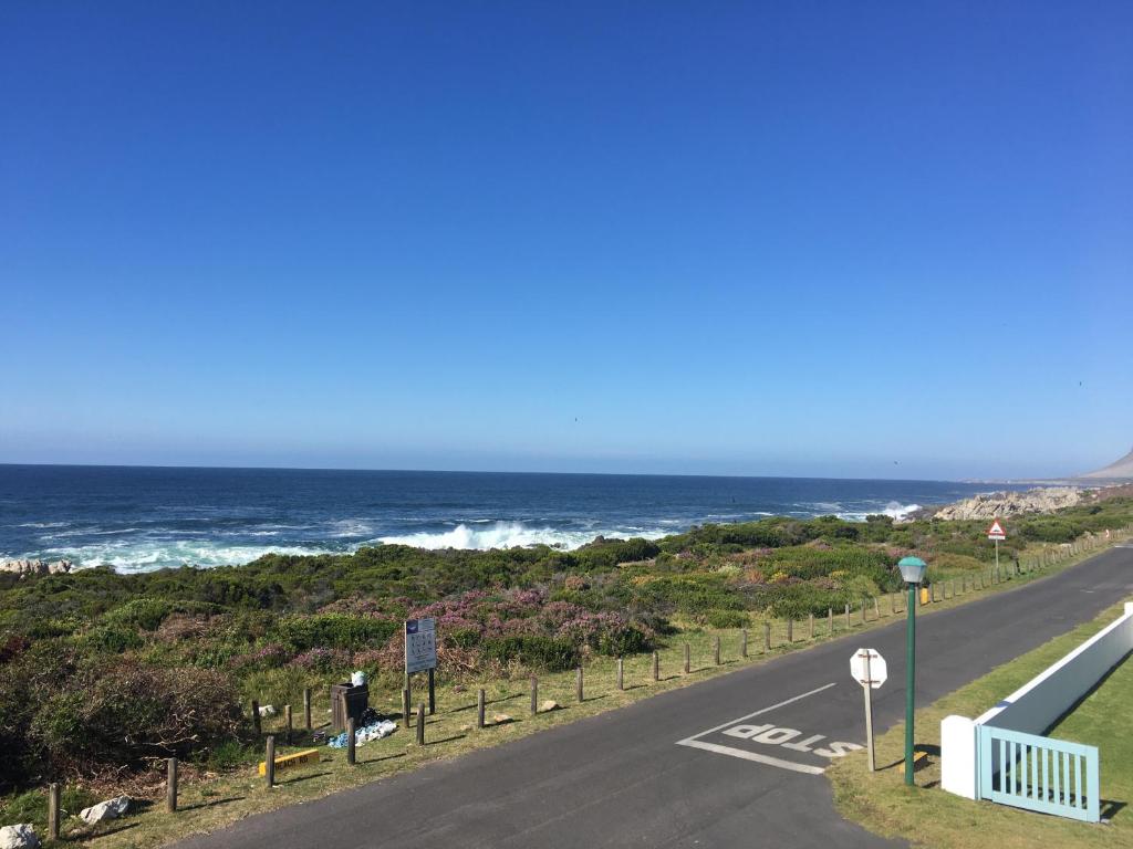 克莱因蒙德Bungalow by the sea near Cape Town的一条空的路,在后面是大海
