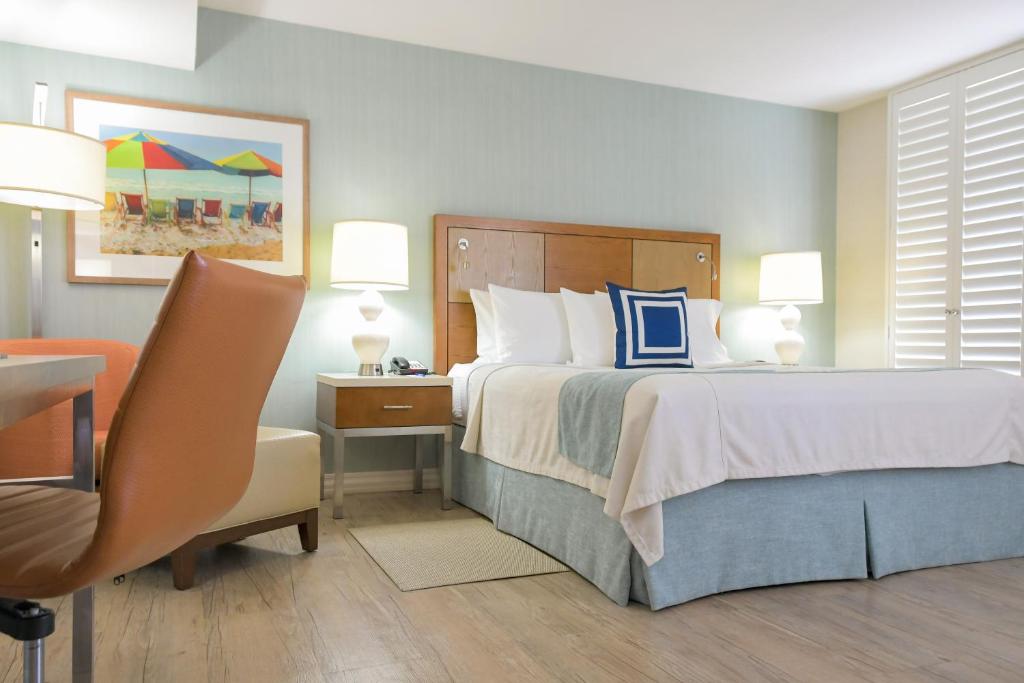洛杉矶圣莫尼卡盖特威酒店的一间卧室配有一张床、一张桌子和一把椅子