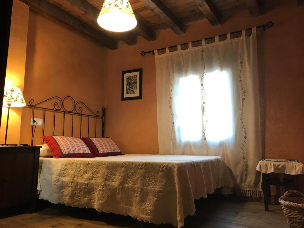 马德里加尔德拉韦拉Casa rural La Piedrapipa的一间卧室设有一张床和一个窗口