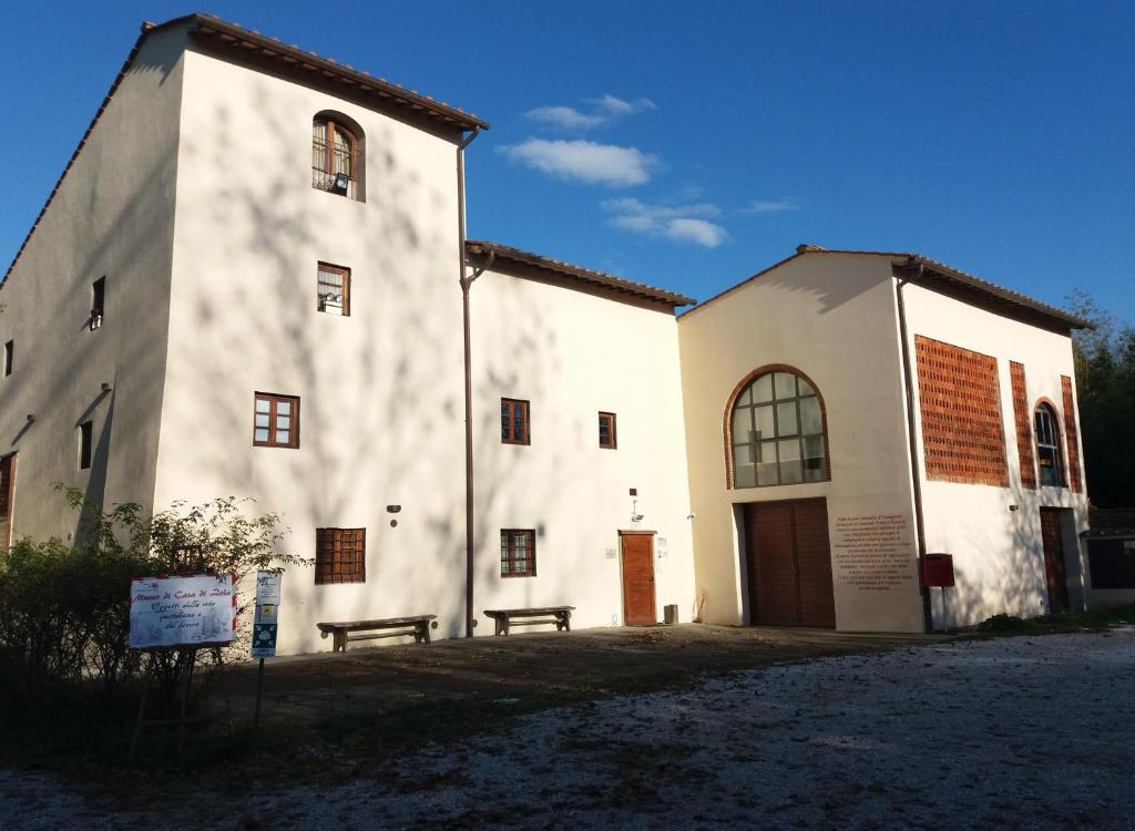 OlmiCasa di Zela的前面有长凳的白色建筑