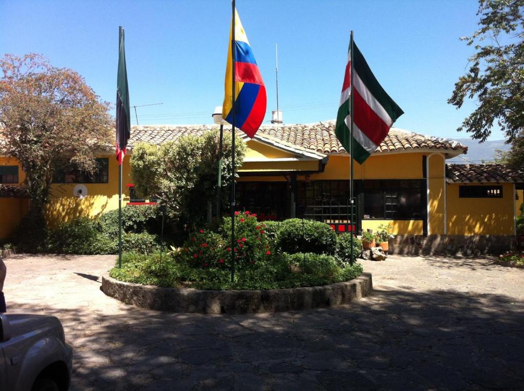 杜伊塔马HH HACIENDA EL CARMEN CENTRO DE CONVENCIONES的建筑物前圆圈上的三面旗