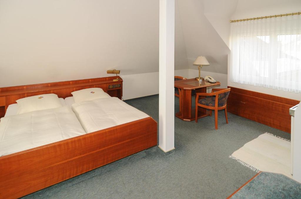 新伊森堡阿尔法公寓酒店 的一间卧室配有一张床、一张桌子和一张桌子
