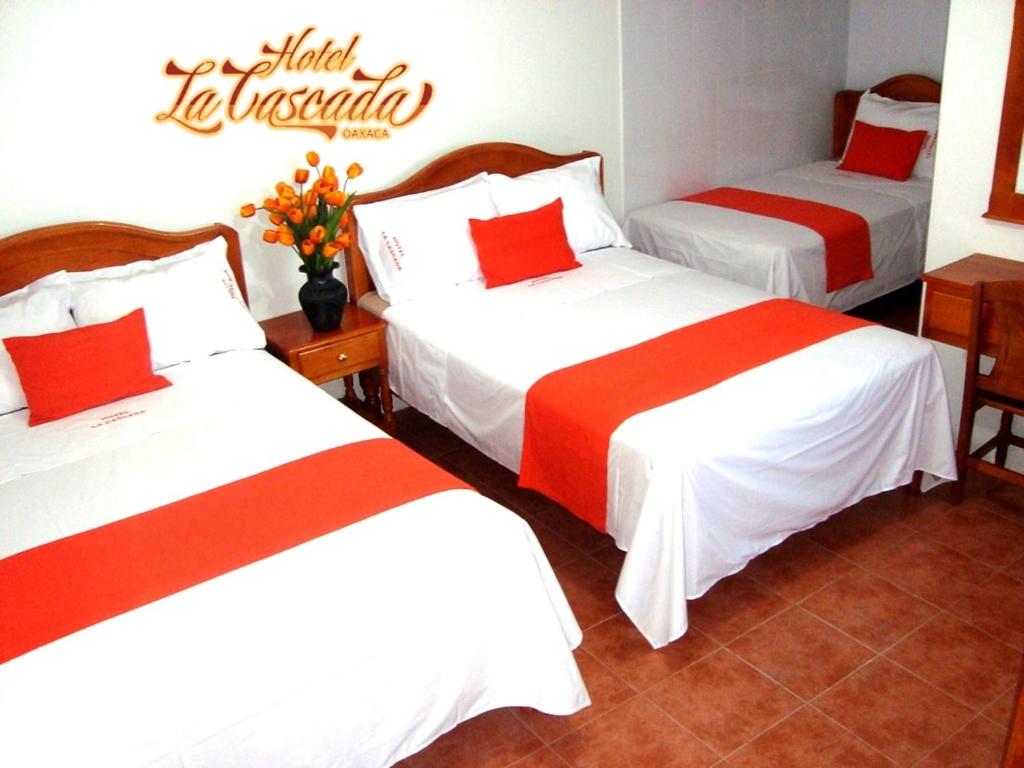 瓦哈卡市拉卡斯卡达酒店的酒店客房带两张红色和白色的床单