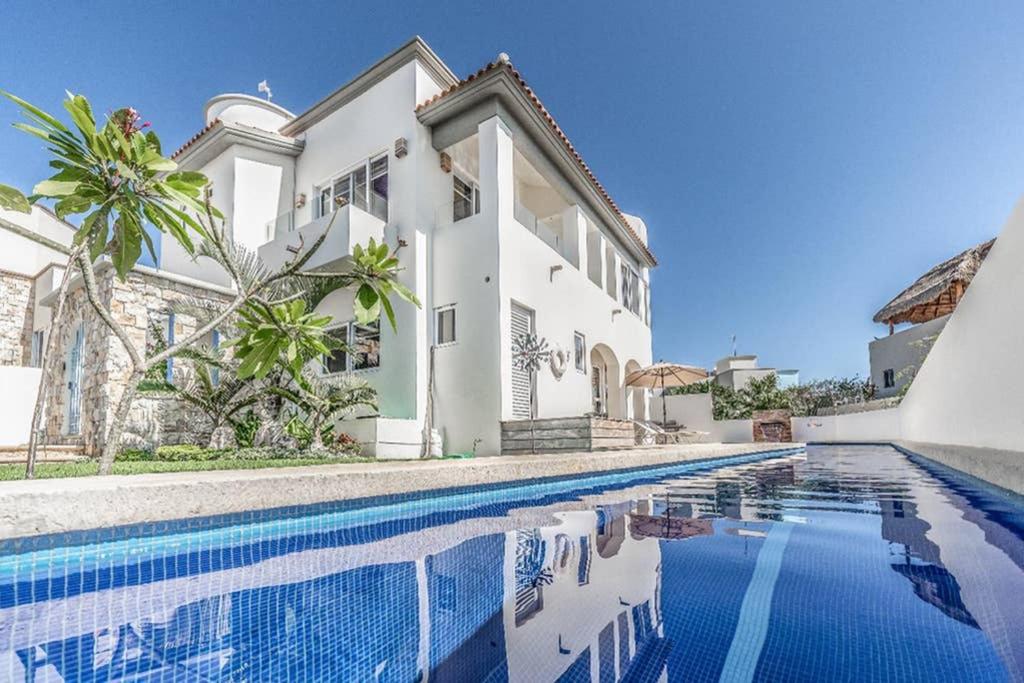 女人岛Casa Santosha的一座白色的房子,前面设有一个游泳池