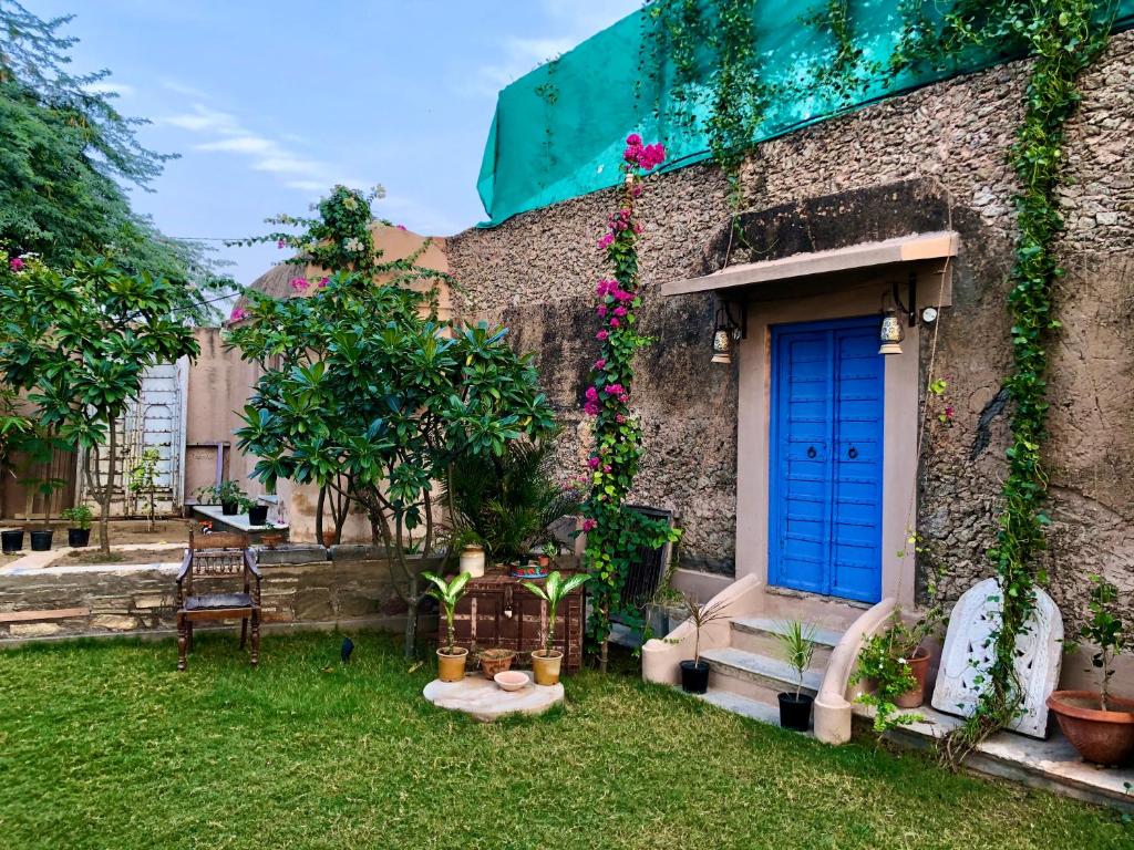 曼达瓦Mandawa Kothi的一座带蓝色门和庭院的房子