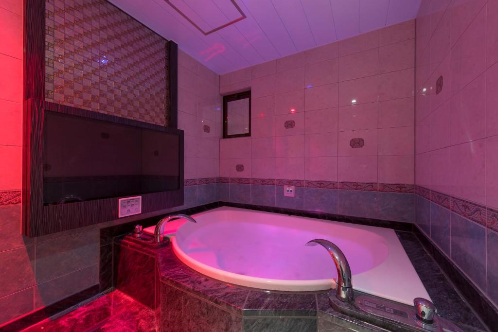 千叶HOTEL W-AVANZA-W GROUP HOTELS and RESORTS-的粉红色的浴室设有落地花卉浴缸