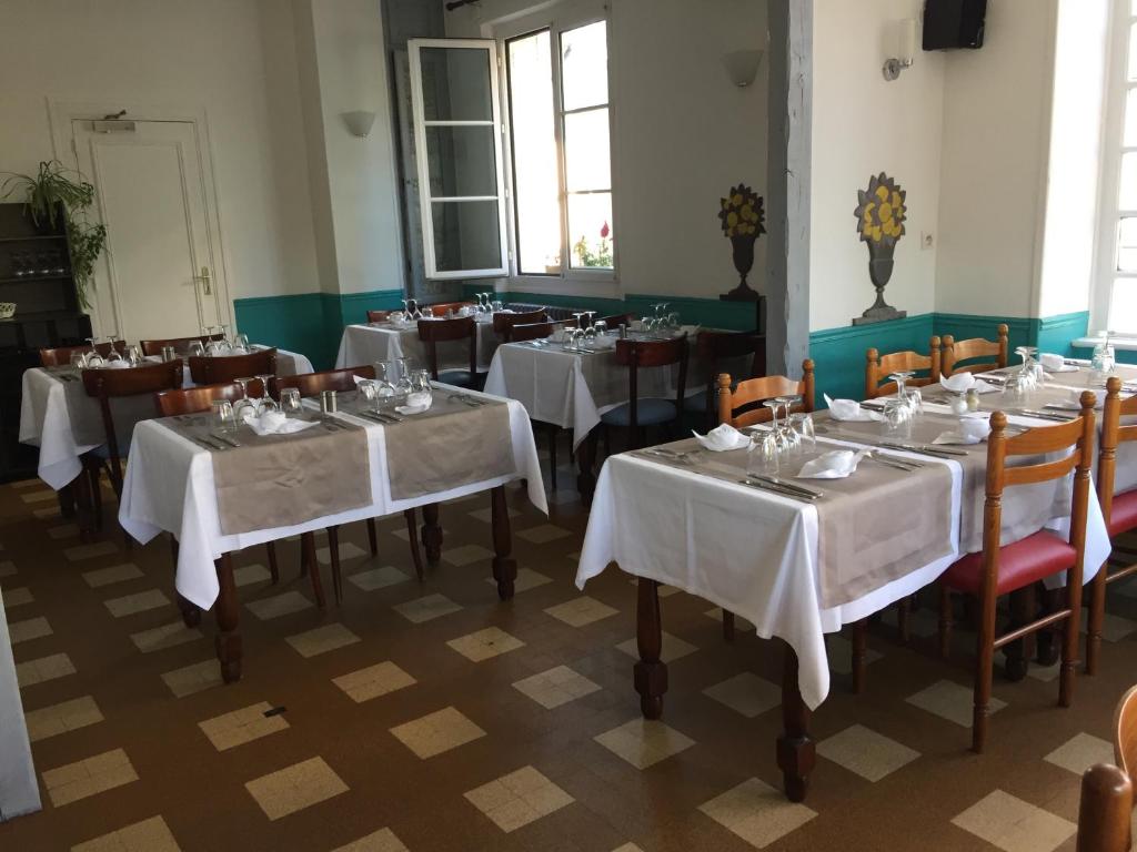 莱格勒西格尼酒店 的用餐室配有桌椅和白色桌布