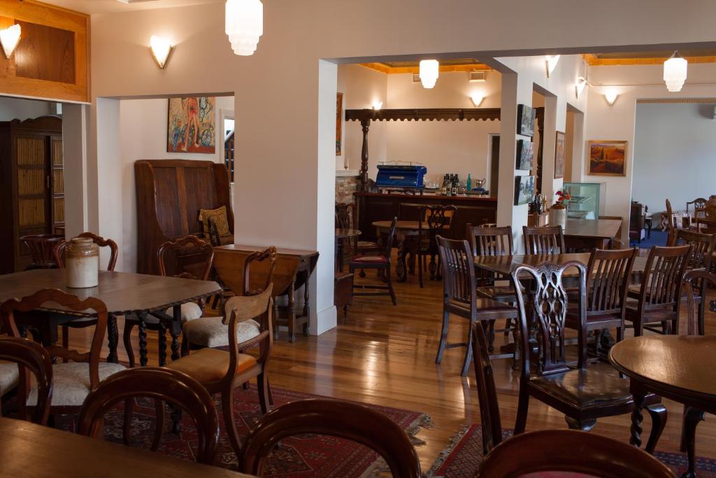 卡斯尔梅恩Northern Arts Hotel的一间带桌椅的餐厅和一间酒吧