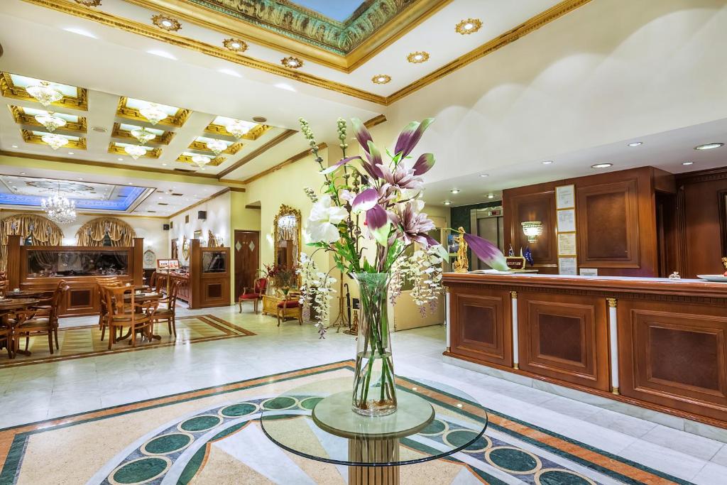 塞萨洛尼基Imperial Palace Classical Hotel Thessaloniki的大堂玻璃桌上的花瓶