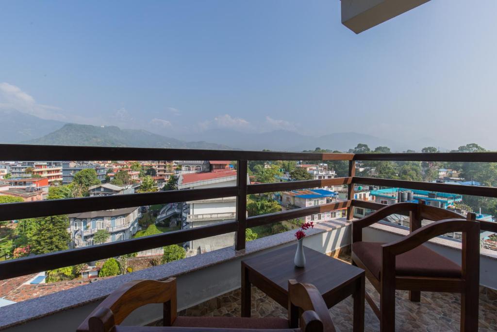 博卡拉Hotel Snow Peak的设有一个配有桌椅并享有美景的阳台。