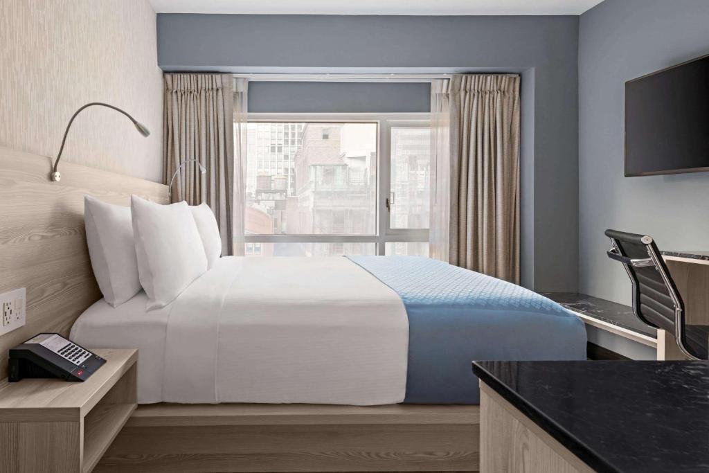 纽约Wingate by Wyndham New York Midtown South/5th Ave的一间设有大床和窗户的酒店客房