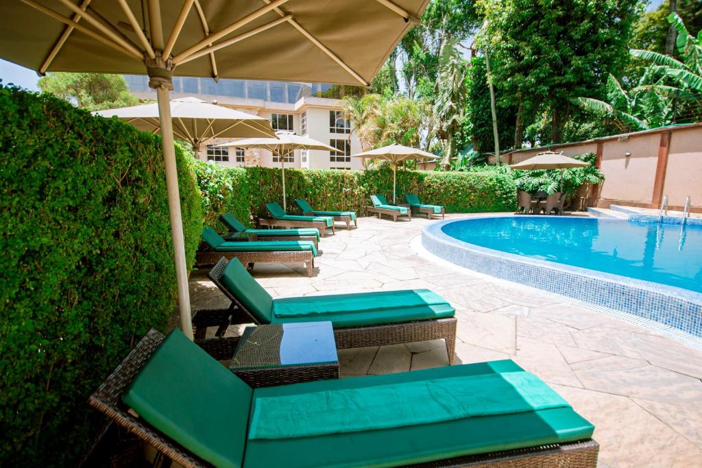 阿鲁沙SG Premium Resort的游泳池旁一排带遮阳伞的椅子