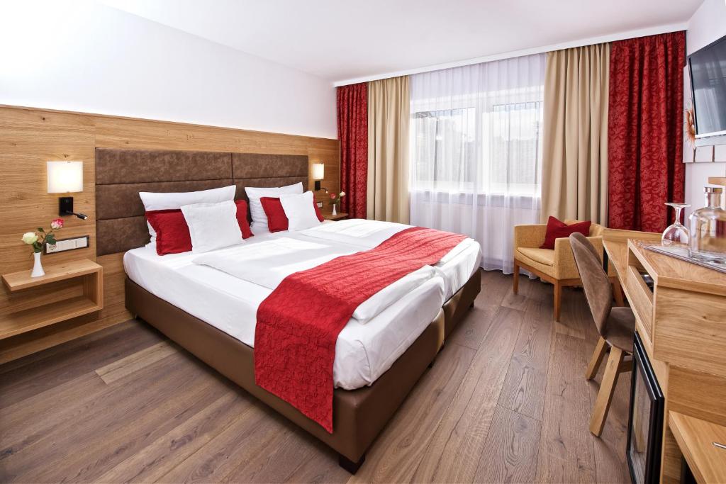慕尼黑莱姆公园酒店的酒店客房设有一张大床和一张书桌。