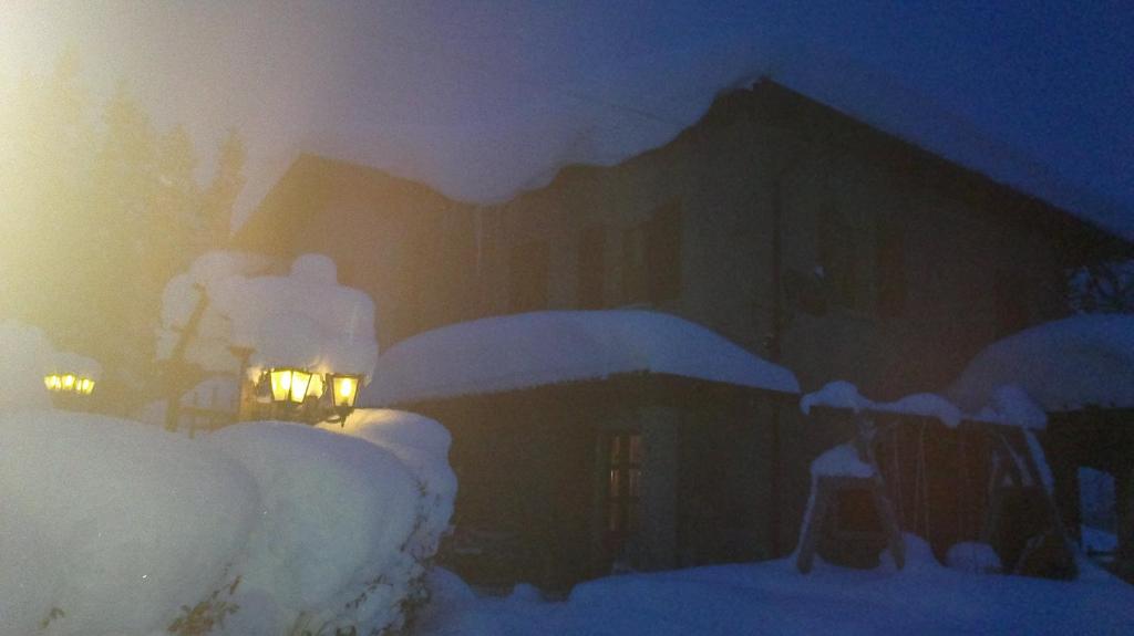 法纳诺RIVAROLA的雪覆盖的房屋,晚上有灯