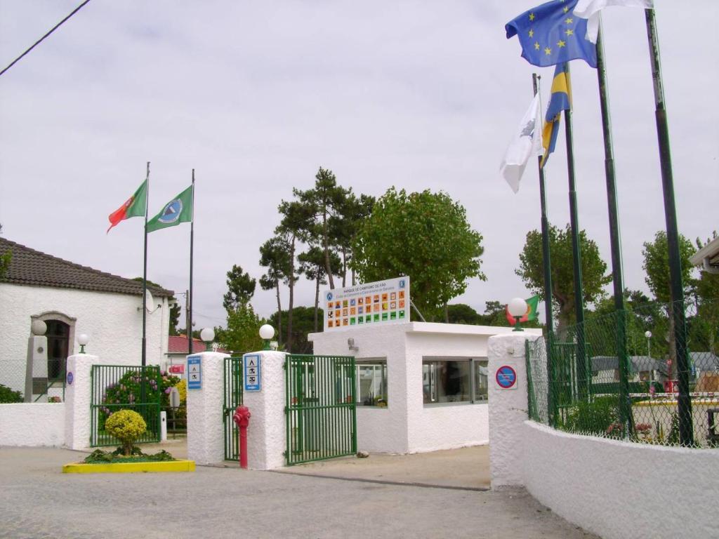 方Parque de Campismo de Fão的前面有门和旗帜的建筑