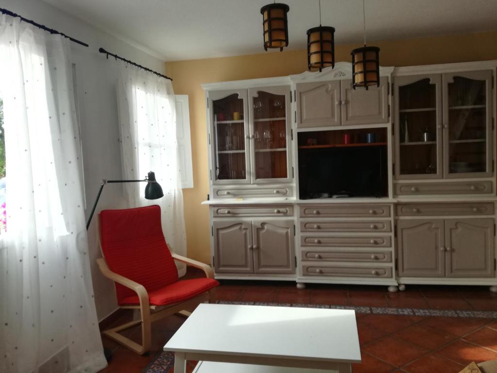 巴耶格兰雷伊Casa La Palomera 1的一间带电视和红色椅子的客厅