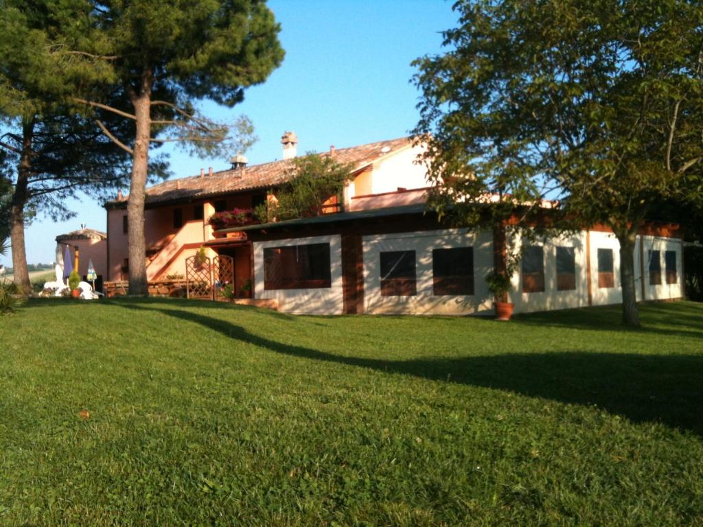 OffagnaAgriturismo Casale il Gallo Bianco的前面有绿色草坪的房子