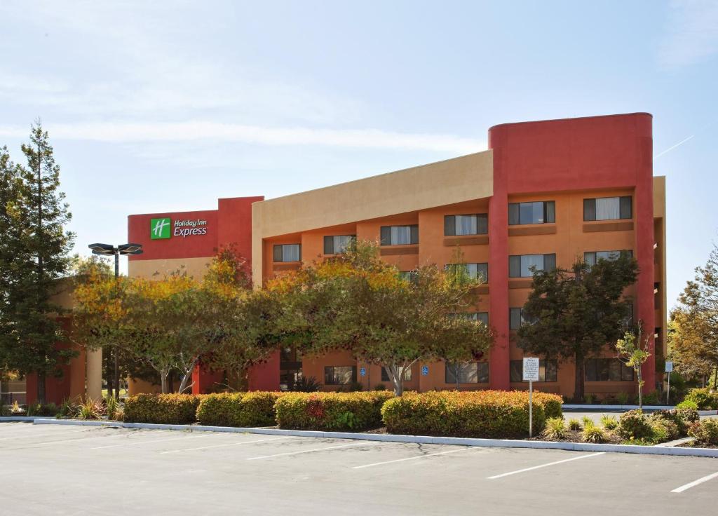 联合市Holiday Inn Express Hotel Union City San Jose, an IHG Hotel的前方设有停车场的办公楼