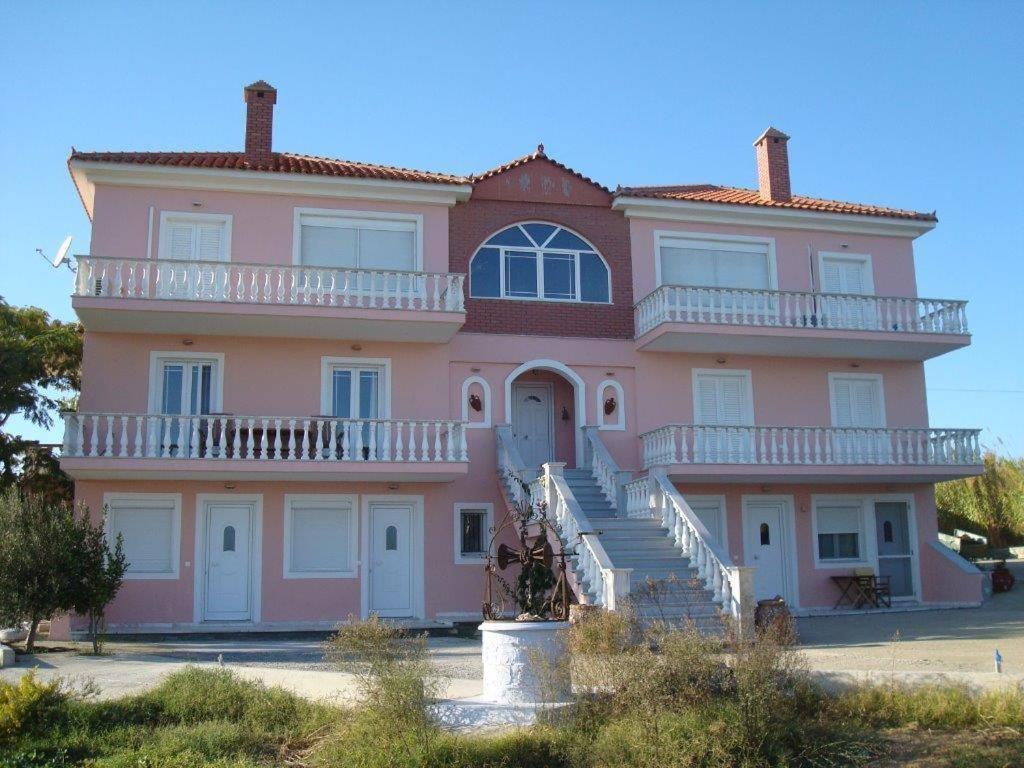 瓦若斯拉戈斯塔别墅公寓的一座大型粉红色房子前面设有楼梯