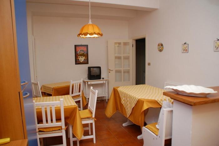 西维尔诺瓦·马尔凯B&B Milù的一间厨房和带两张桌子及椅子的用餐室
