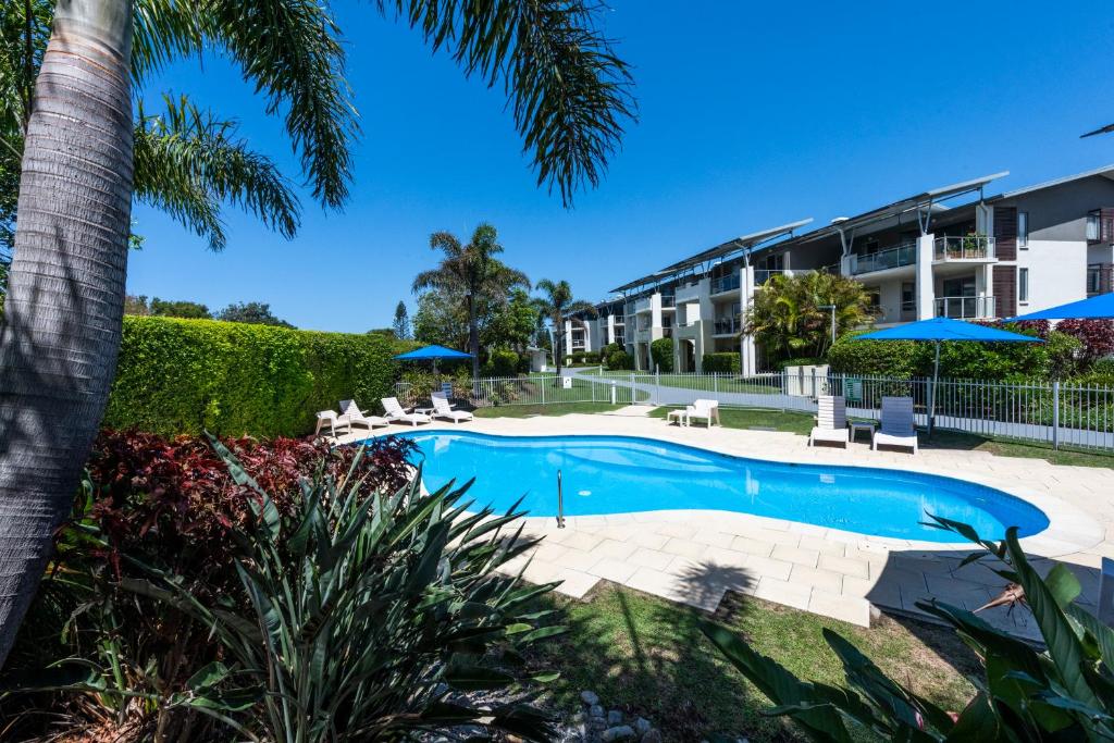 科夫斯港太平洋滨海公寓式酒店的一个带椅子和遮阳伞的度假游泳池