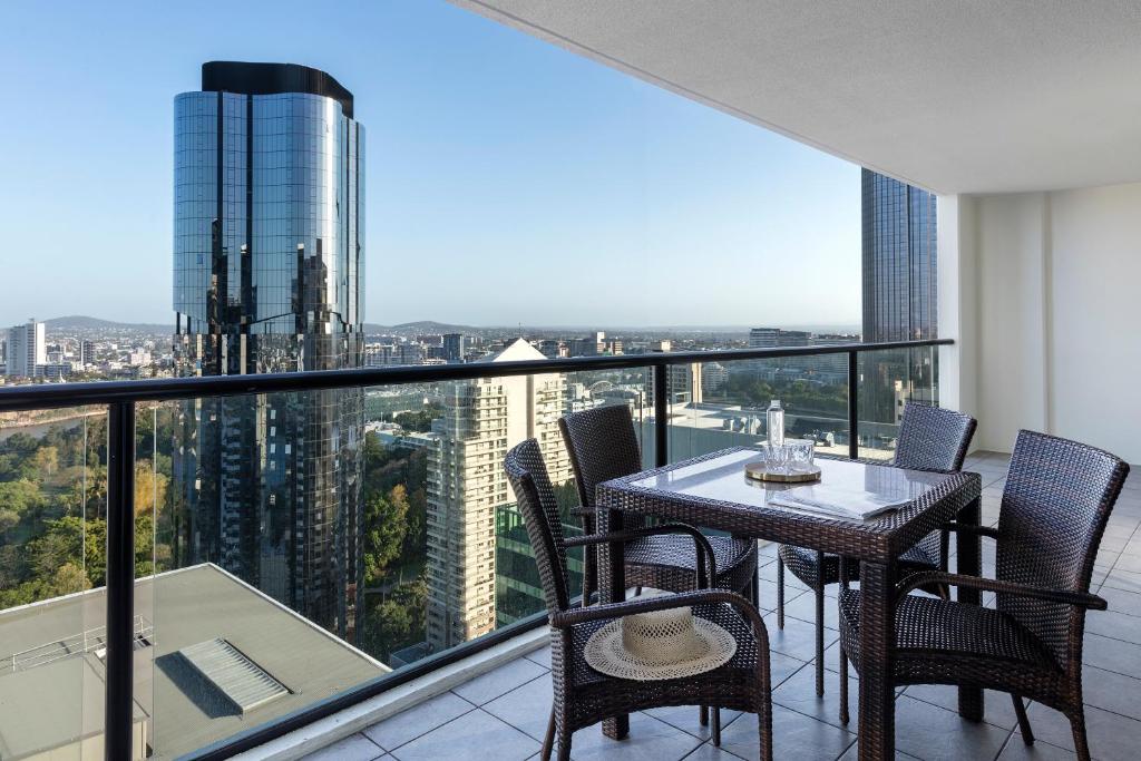 布里斯班iStay River City Brisbane的阳台的用餐室配有桌椅