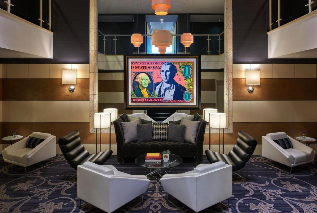 华盛顿金普顿乔治酒店的大堂配有沙发、椅子和电视