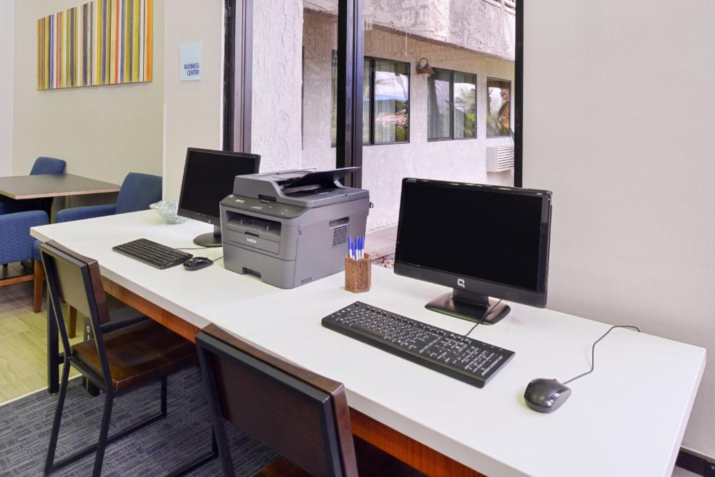 棕榈荒漠棕榈沙漠智选假日酒店的办公室,配有一张桌子、一台电脑和一台打印机