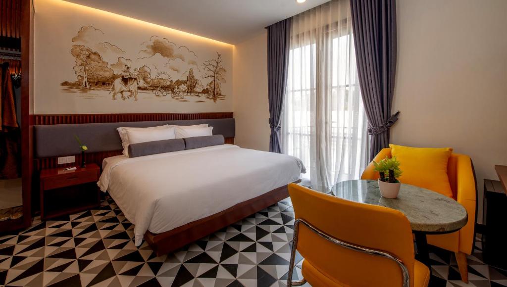 暹粒The Twizt - Lifestyle Hostel的酒店客房配有一张床铺和一张桌子。