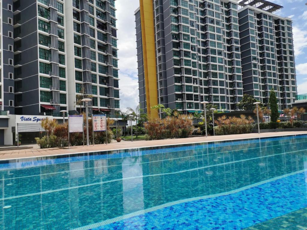 莎阿南Vista Alam Studio Units - Pool, food court的一座游泳池,有两座高楼