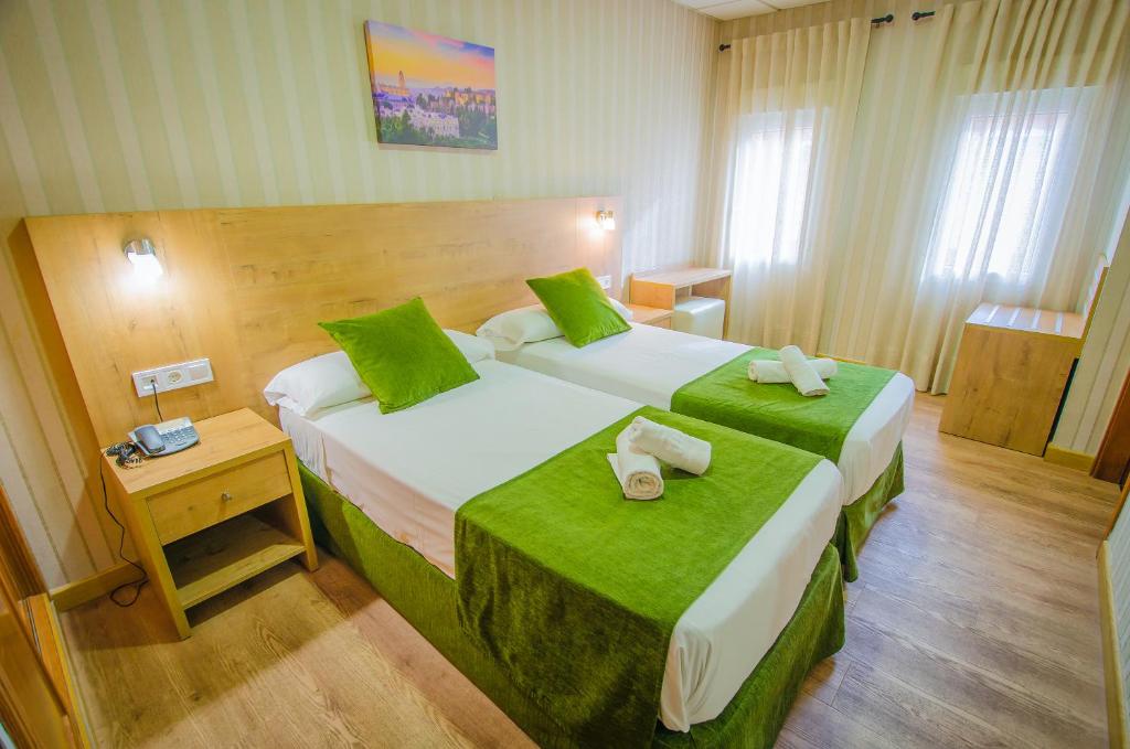 马拉加索利玛酒店的酒店客房,配有两张带绿床单的床