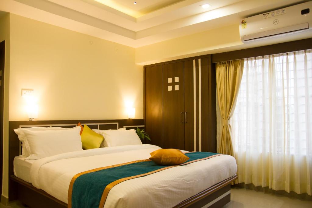 古瓦哈提Hotel Park Riviera的一间卧室设有两张床和窗户。