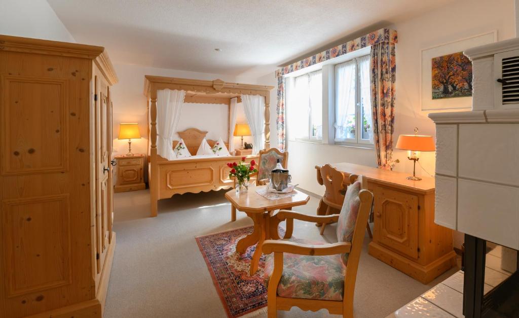 Brunegg三颗星浪漫酒店的带桌子的房间和一间带床的卧室
