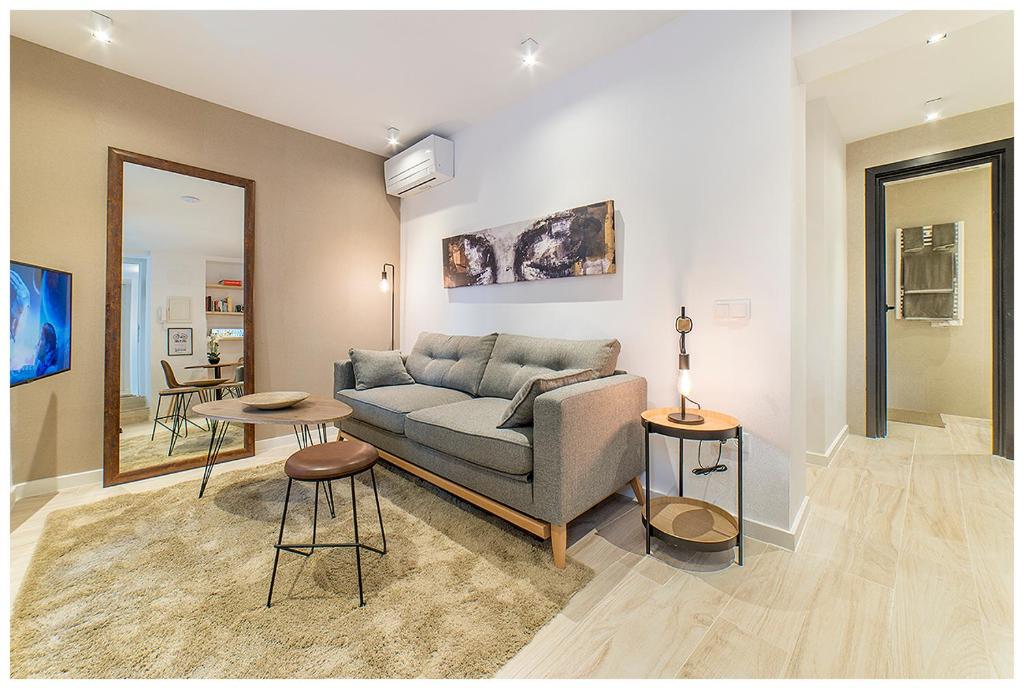 马德里Apartamentos Madrid Rio的客厅配有沙发和桌子