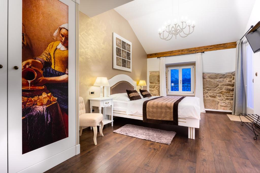 巴斯卡文物坲扎酒店的卧室配有一张床,墙上挂有绘画作品