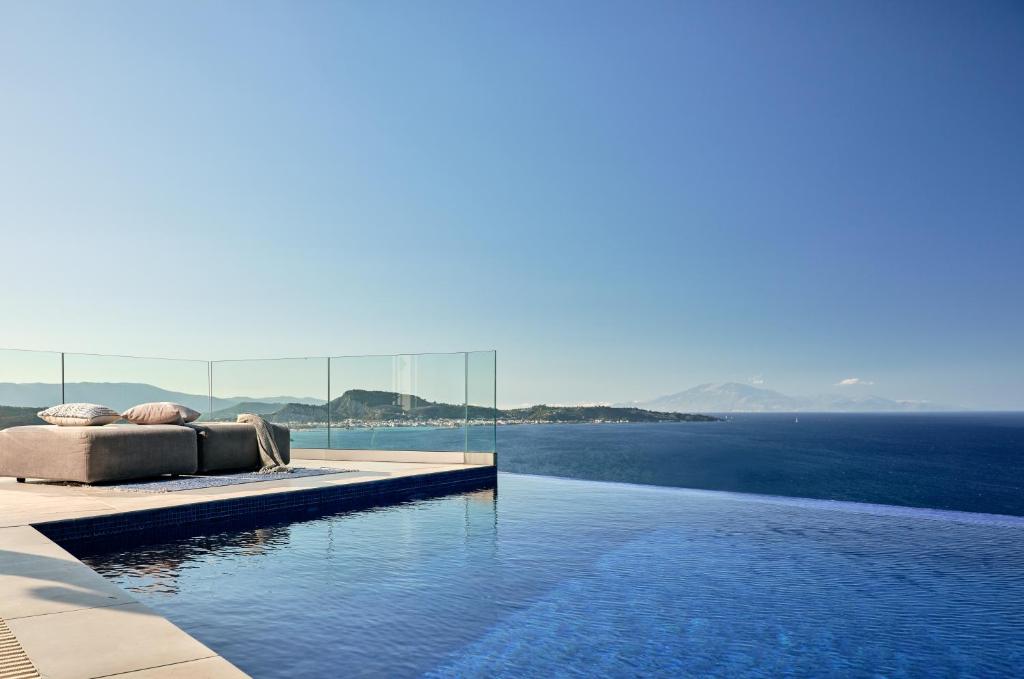 阿凯松Iconic Ionian Mudita Villa, By ThinkVilla的游泳池旁设有一张床