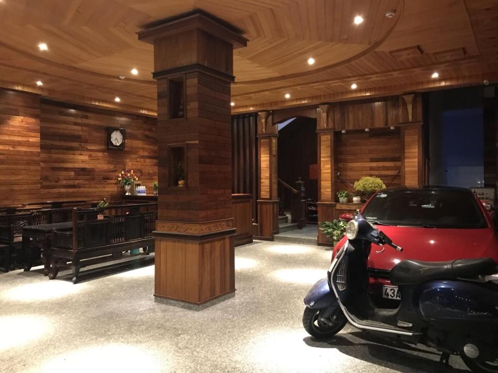 岘港Salyna Motel的摩托车停在一个有时钟的房间