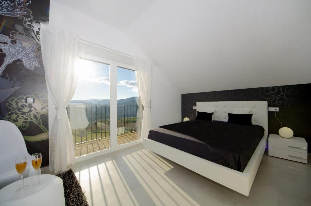 AraguásCasa Rural La Esencia的一间卧室设有一张床和一个大窗户