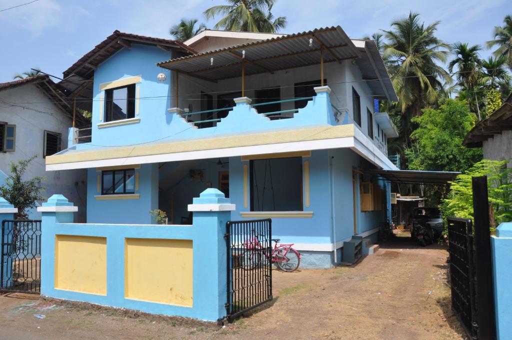 卡希德Suvarna Holiday Home的前面有栅栏的蓝色房子