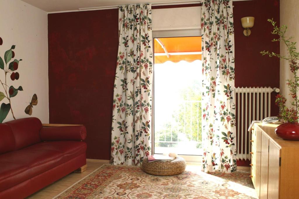 曼德沙伊德Landhotel Pension Haus Sonneck的客厅设有红色的沙发和窗户。