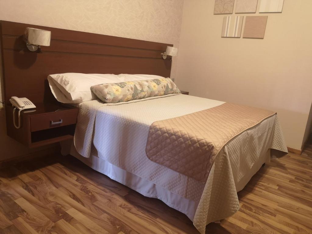 塔里哈Hostal Palamas的一间卧室配有一张床,铺有木地板