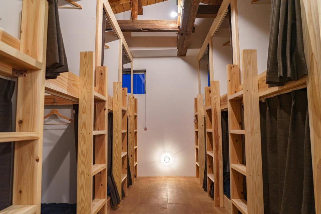 Saikiゲストハウス さんかくワサビ的客房内的一排木制双层床